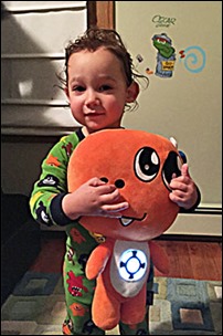 A child playing with the TREX: Shine Force Brobo plush toy