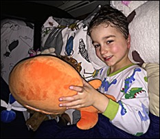 A child sleeping with the TREX: Shine Force Brobo plush toy